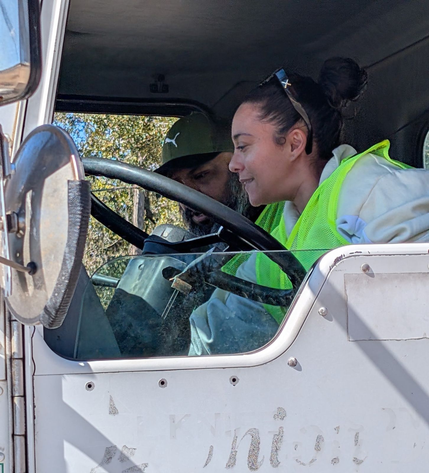 A prospective student smiling behind the wheel of a truck for the first time during a free session