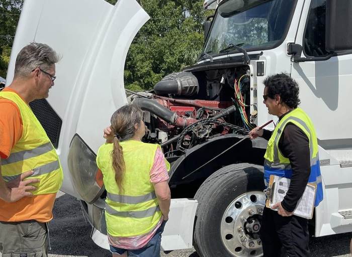 An instructor walking students through an engine pre-trip inspection lesson
