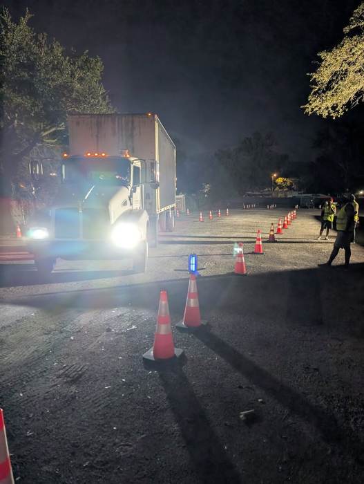 A training truck backing through cones during a night CDL class