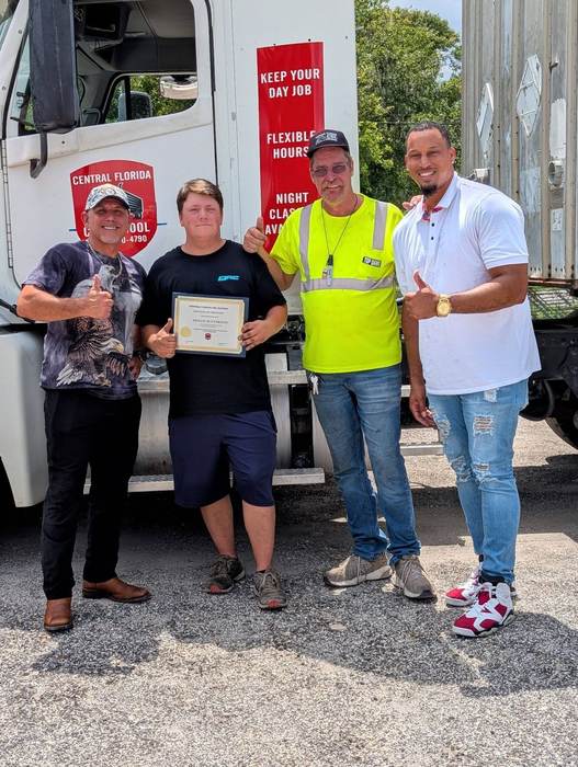 Central Florida CDL School graduate Shaun M. Everson holding his certificate of completion with instructors
