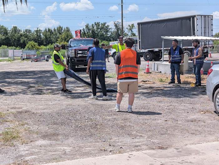 Students carrying a curtain-side trailer tarp during hands-on equipment training
