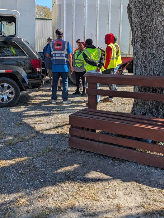 A group of prospective students gathered near a trailer during a free hands-on session