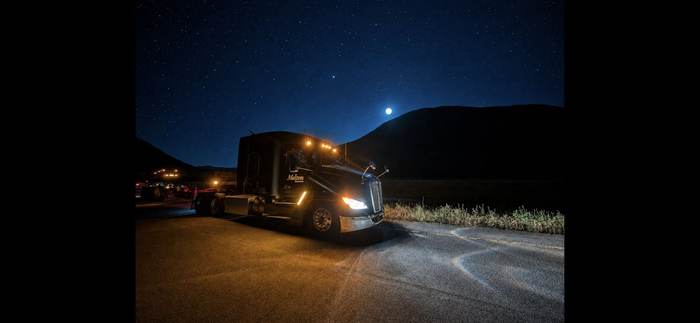A Melton Truck Lines truck parked under a starry night sky